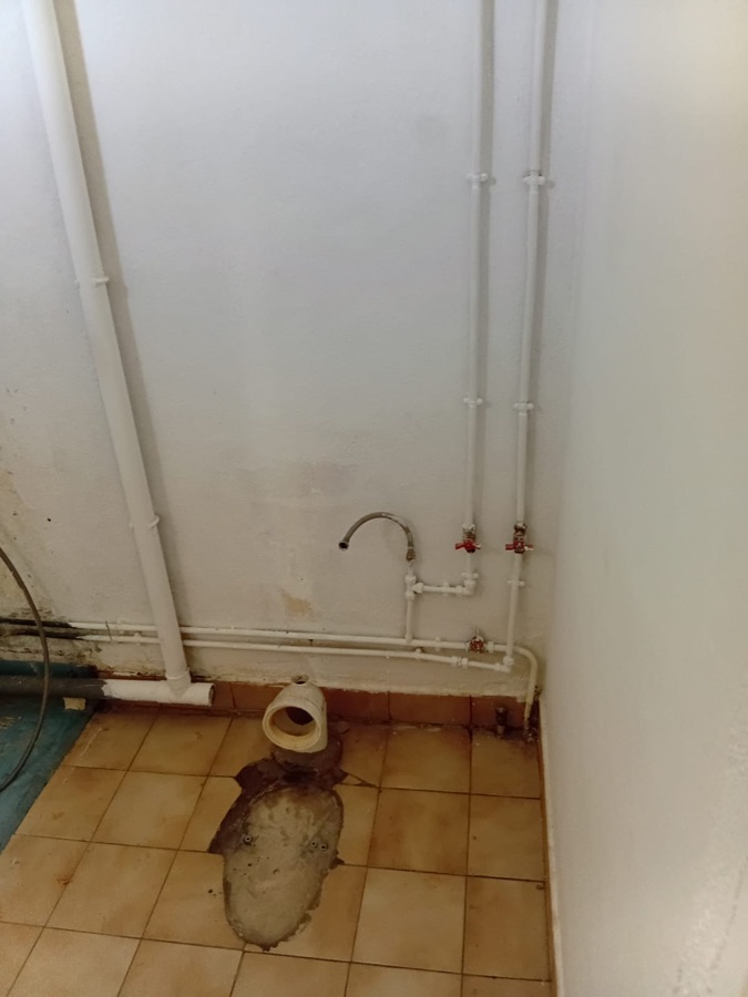 WC avant rénovation : équipement déposé, canalisations apparentes